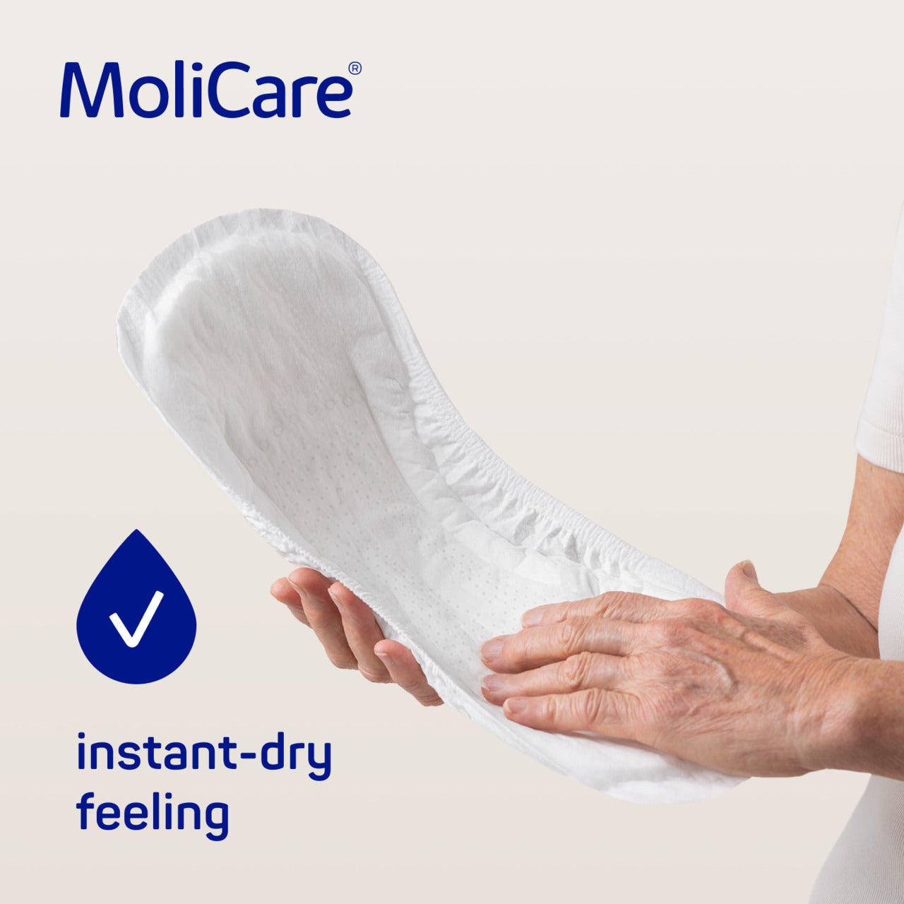 MoliCare product with hands holding it, emphasizing instant-dry feeling on a light background.