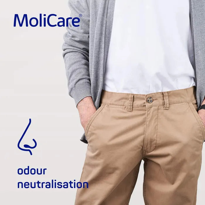 Person wearing beige pants with MoliCare branding and odor neutralization feature on a light gray background