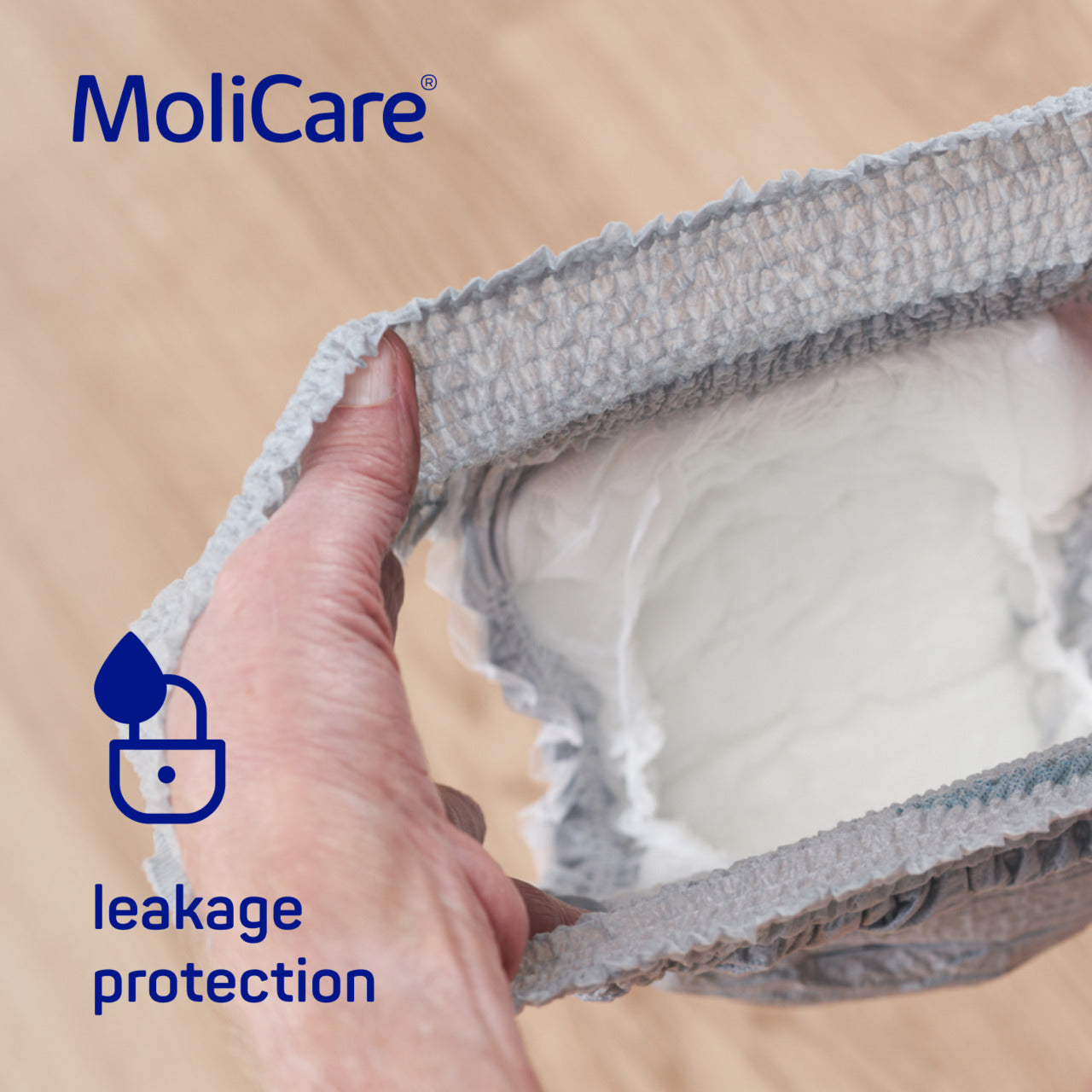 MoliCare product with leakage protection feature being held by a hand on a beige background