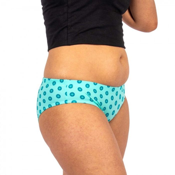 Person wearing turquoise polka dot underwear on a white background