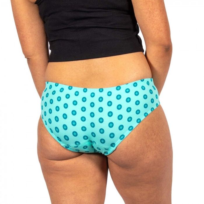 Person wearing turquoise polka dot underwear on a white background