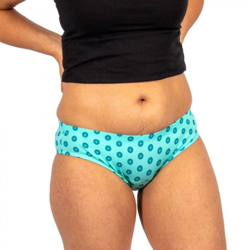 Person wearing turquoise polka dot underwear with a black top on a white background