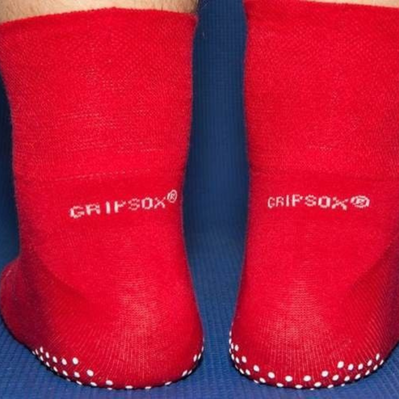 Red socks with white polka dots and 'Grip Sox' branding on a blue background