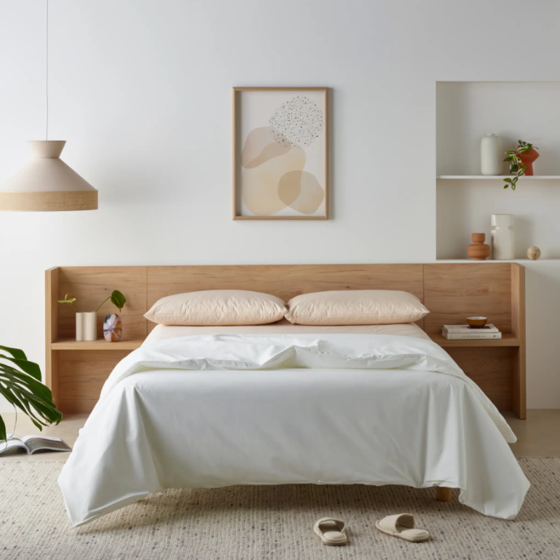 Bedroom with wooden headboard, white bedding, and minimal decor.