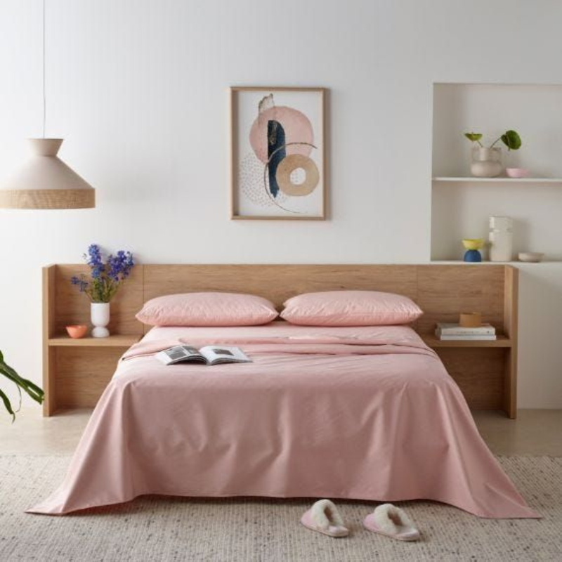 Bedroom with pink bedding and wooden headboard