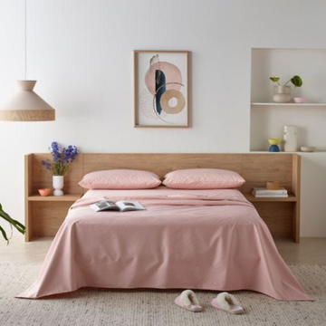 Bedroom with pink bedding and wooden headboard