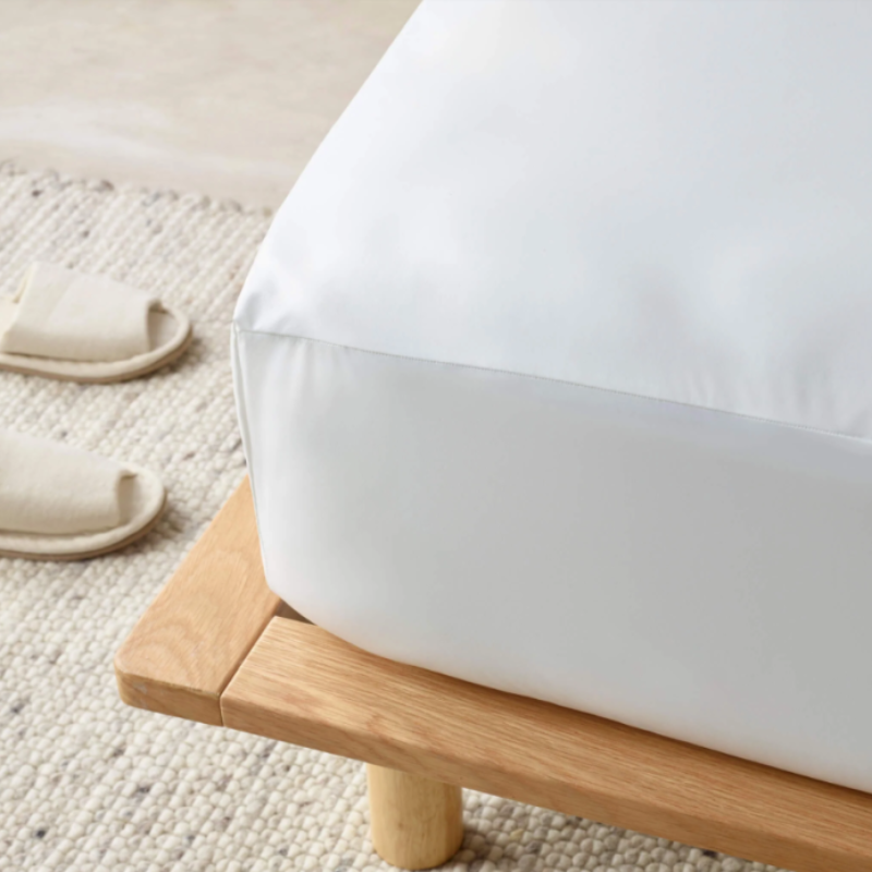 White mattress on a wooden platform with a neutral background