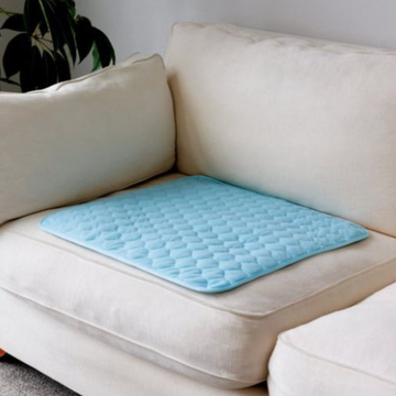 Light blue quilted mat on a beige sofa with a neutral background