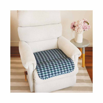 White armchair with a blue checkered cushion, placed in a room with a side table and flowers.