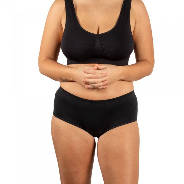 Person wearing a black bra and black underwear on a white background