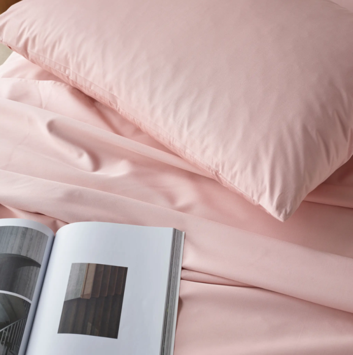 Bedroom with pink bedding and wooden headboard
