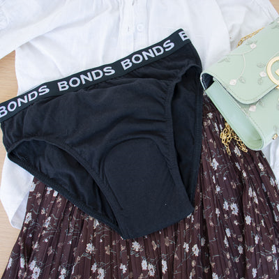 Black Bonds underwear on a floral skirt with a white shirt and green bag in the background