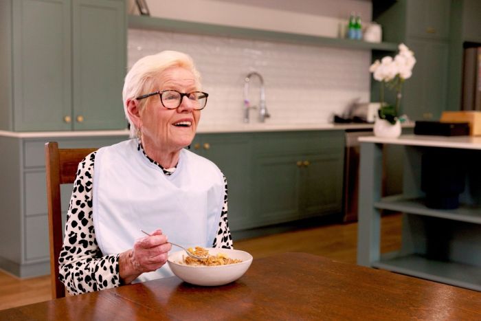 Woman eating cereal at a kitchen table with a homey atmosphere