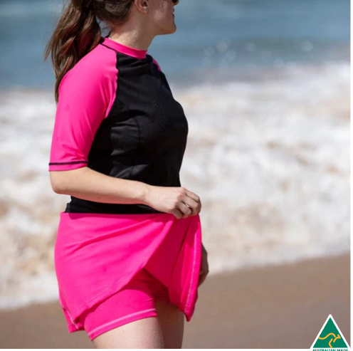 Person wearing a black and pink Rash Guard on a beach