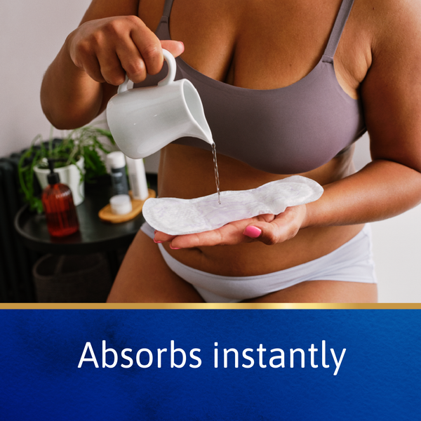 Person pouring liquid onto a white pad held in their hands with text 'Absorbs instantly' at the bottom.